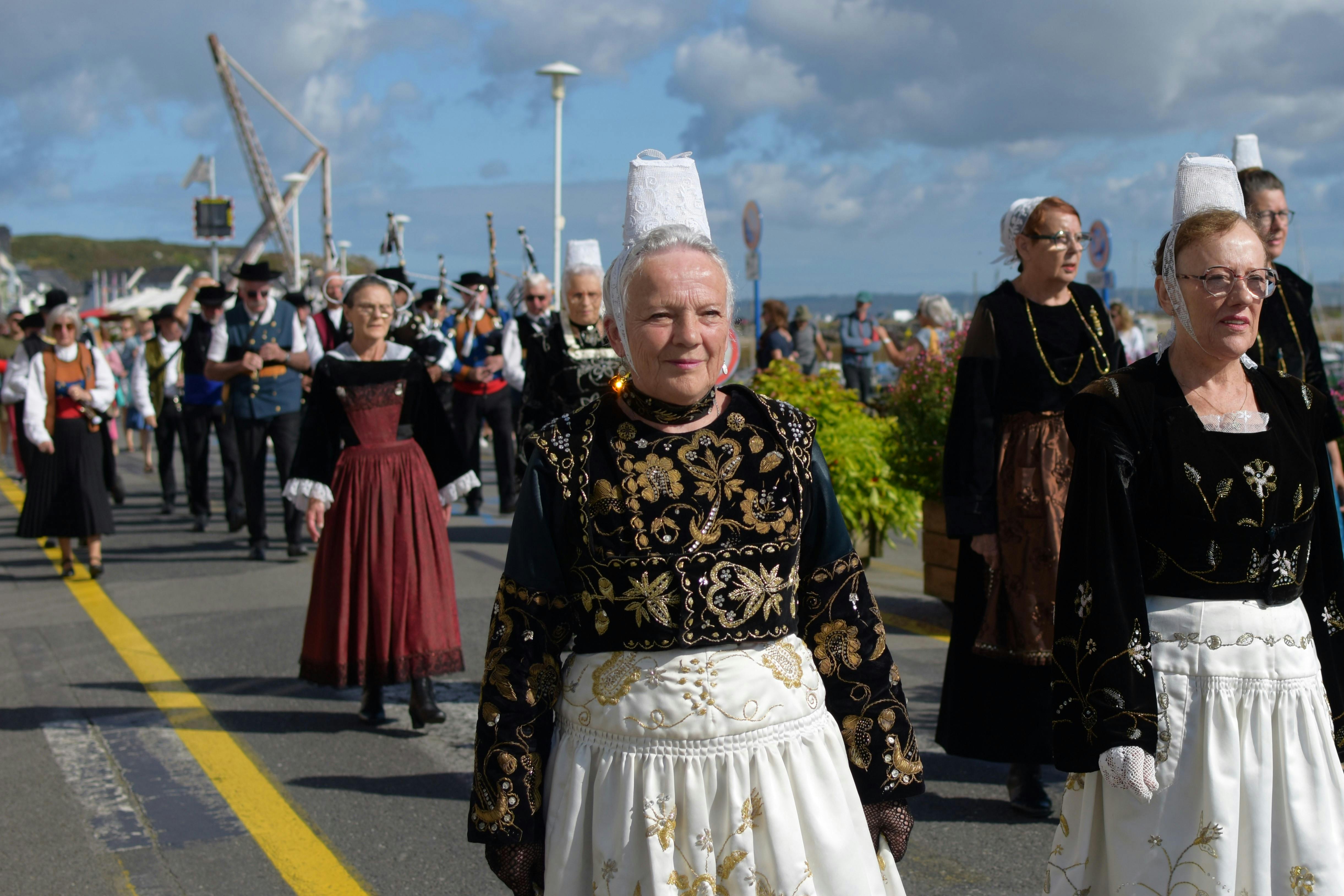 fête-en-bretagne Un groupe de femme et d'homme en costume traditionnel débout les uns auprès des autres